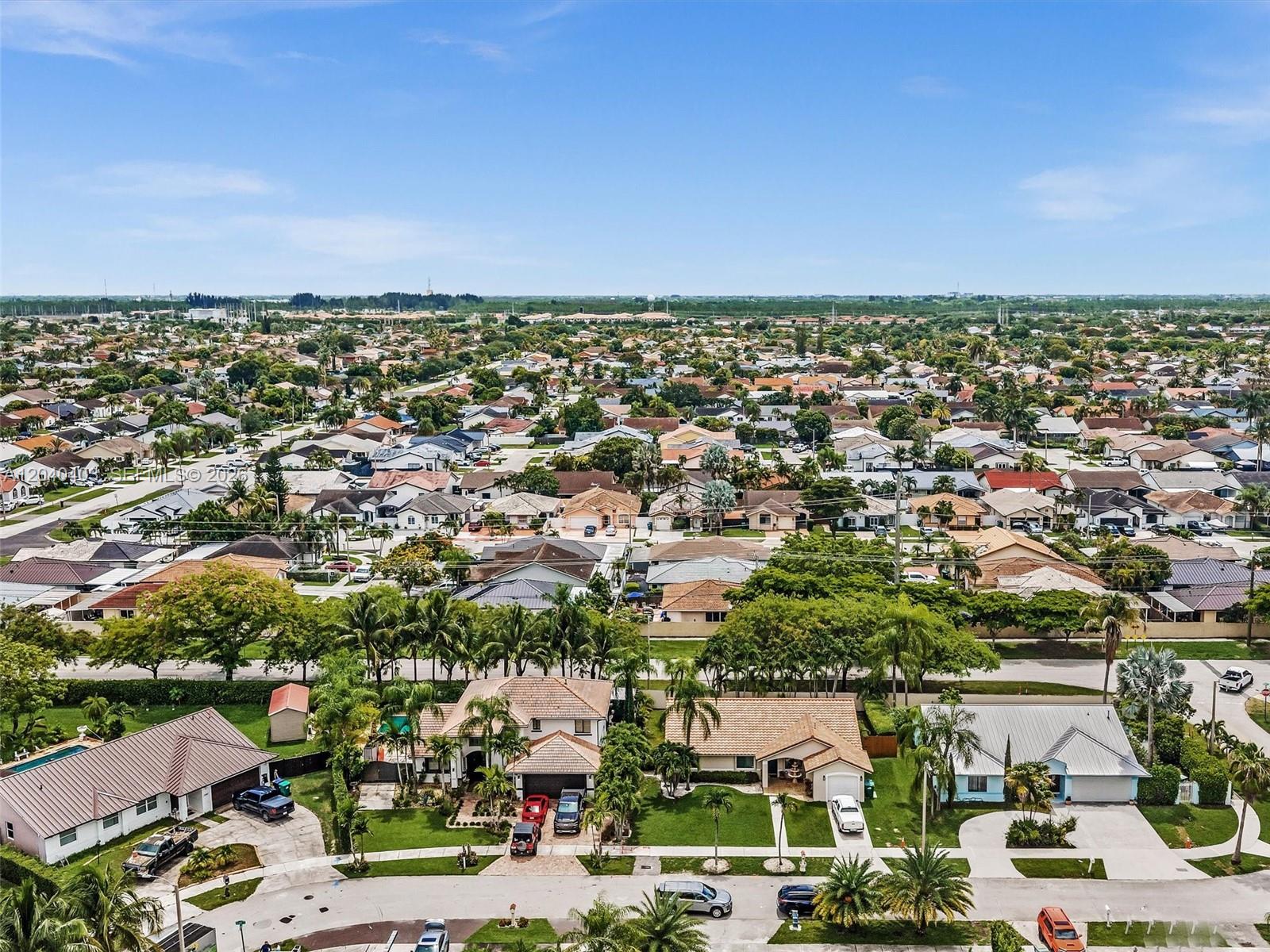 An aerial view shows a suburban neighborhood with single-family homes, palm trees, and paved streets — 16951 SW 147th Ct, Miami FL 33187, MIAMI, FL