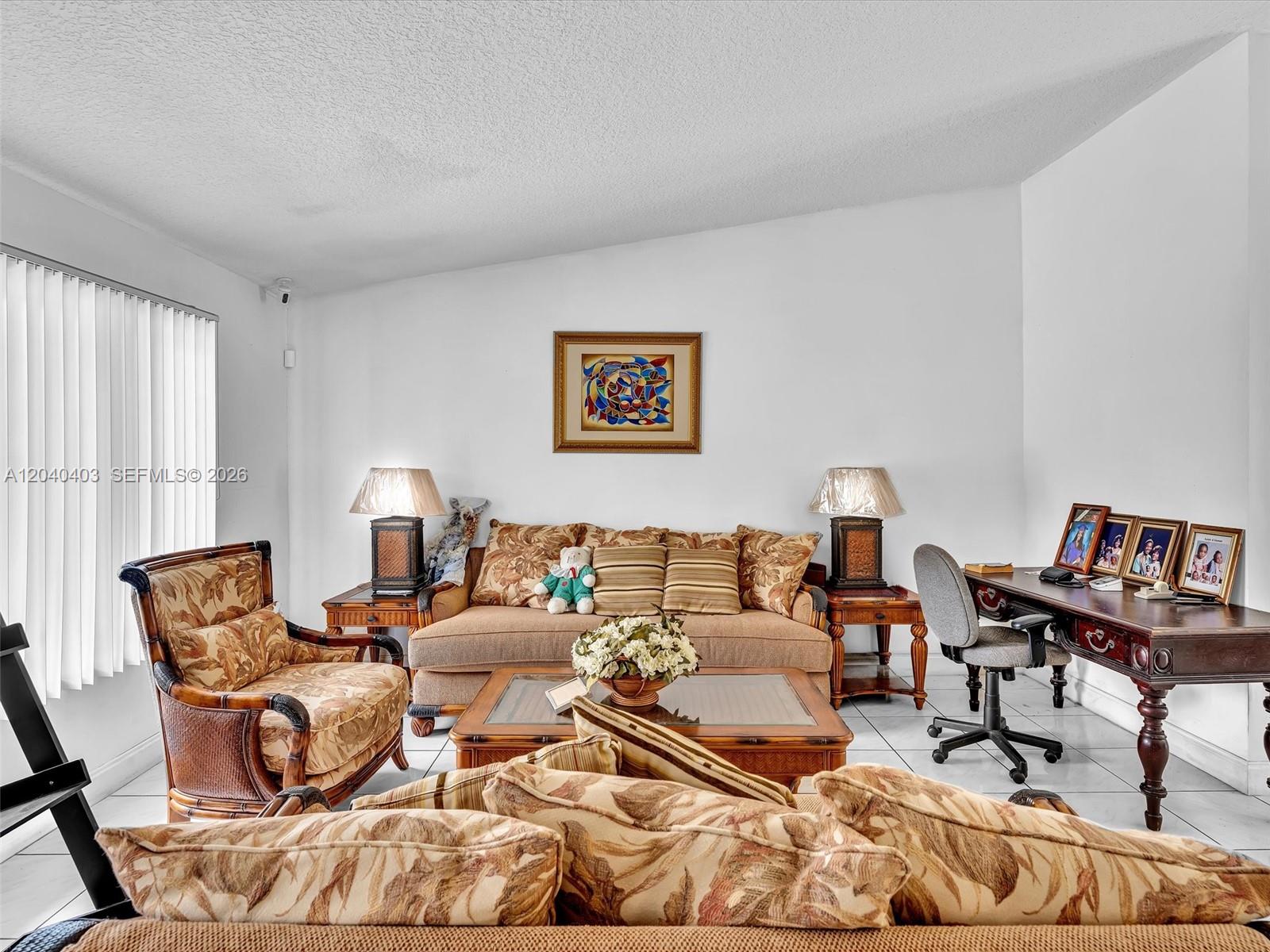 A living room features a sofa, armchair, coffee table, and desk on tiled flooring — 16951 SW 147th Ct, Miami FL 33187, MIAMI, FL
