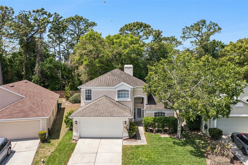 An aerial view shows a two-story beige house with a shingled roof and driveway — 617 RANDON TERRACE, LAKE MARY, FL