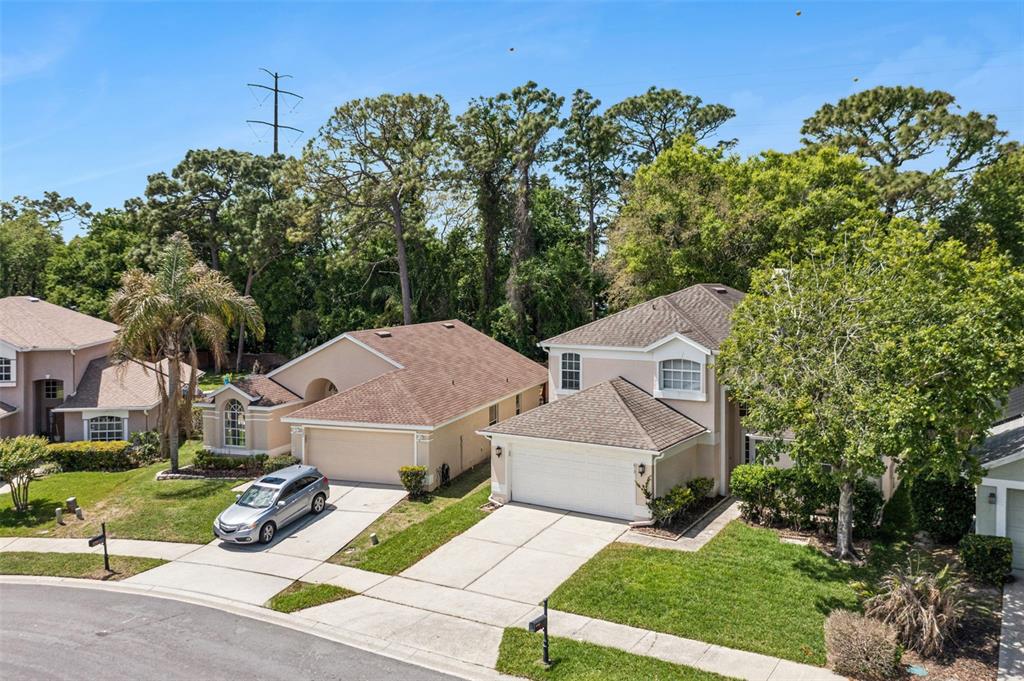 An aerial view shows two suburban houses with beige stucco exteriors and brown shingled roofs — 617 RANDON TERRACE, LAKE MARY, FL