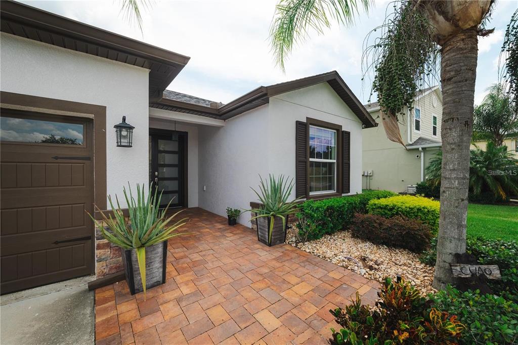 A paved walkway leads to the front entrance of a house with a garage — 5635 FISHER GLEN LOOP, WESLEY CHAPEL, FL