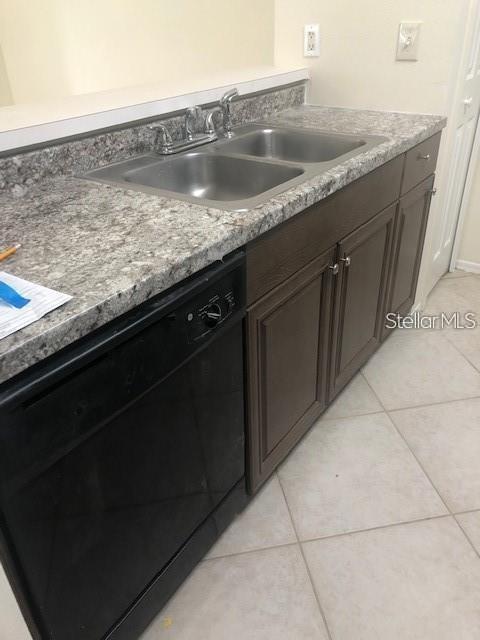 A kitchen features a double-basin stainless steel sink, granite-look countertops, and dark wood cabinets — 1735 FLUORSHIRE DRIVE, BRANDON, FL