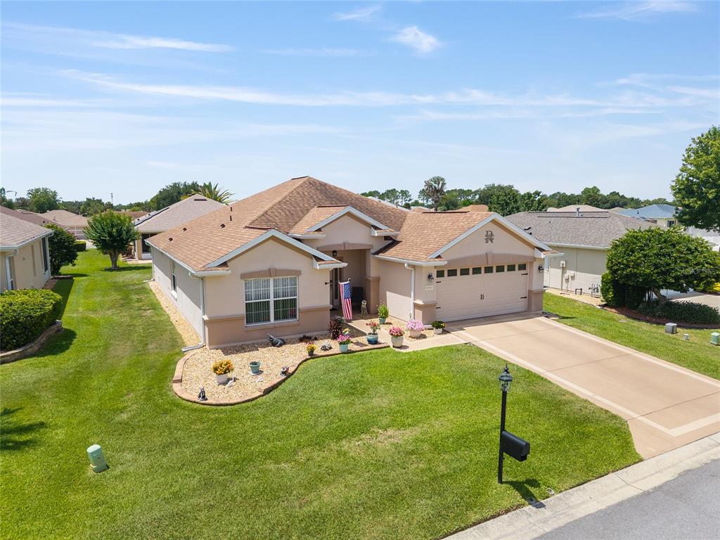 A single-story suburban house with a tan exterior, brown roof, and a two-car garage — 8716 SE 136TH PLACE, SUMMERFIELD, FL
