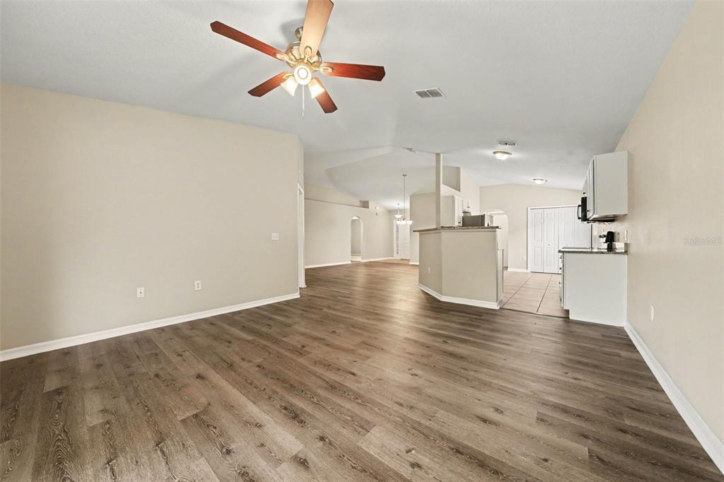 A living room features a gray sofa, wood coffee table, and sliding glass doors — 2208 NICOLLETT WAY, LEESBURG, FL