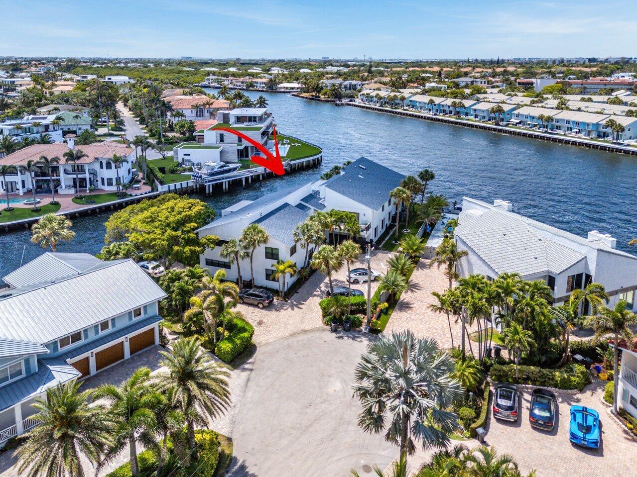 An aerial view shows waterfront homes with private docks and palm trees along a canal — 1102 Highland Beach Drive # 2w, Highland Beach FL 33487, HIGHLAND BEACH, FL