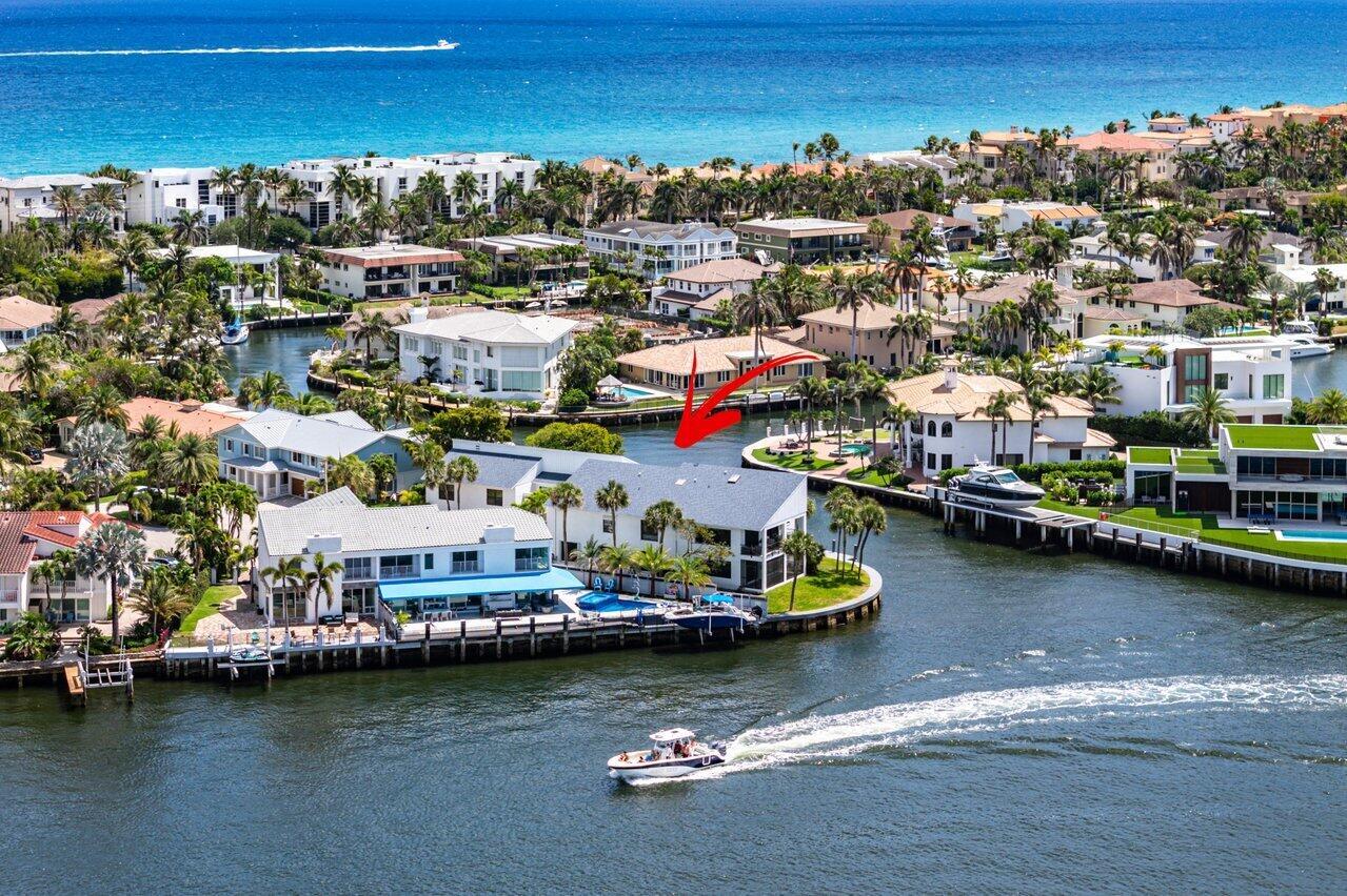 An aerial view of a waterfront house with a pool, dock, and boat on a canal — 1102 Highland Beach Drive # 2w, Highland Beach FL 33487, HIGHLAND BEACH, FL