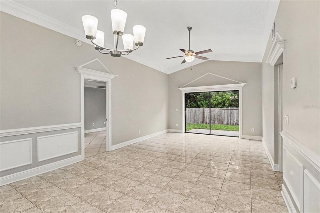 A dining room with tile floors, a chandelier, a ceiling fan, and sliding glass doors — 134 CORALWOOD CIRCLE, KISSIMMEE, FL