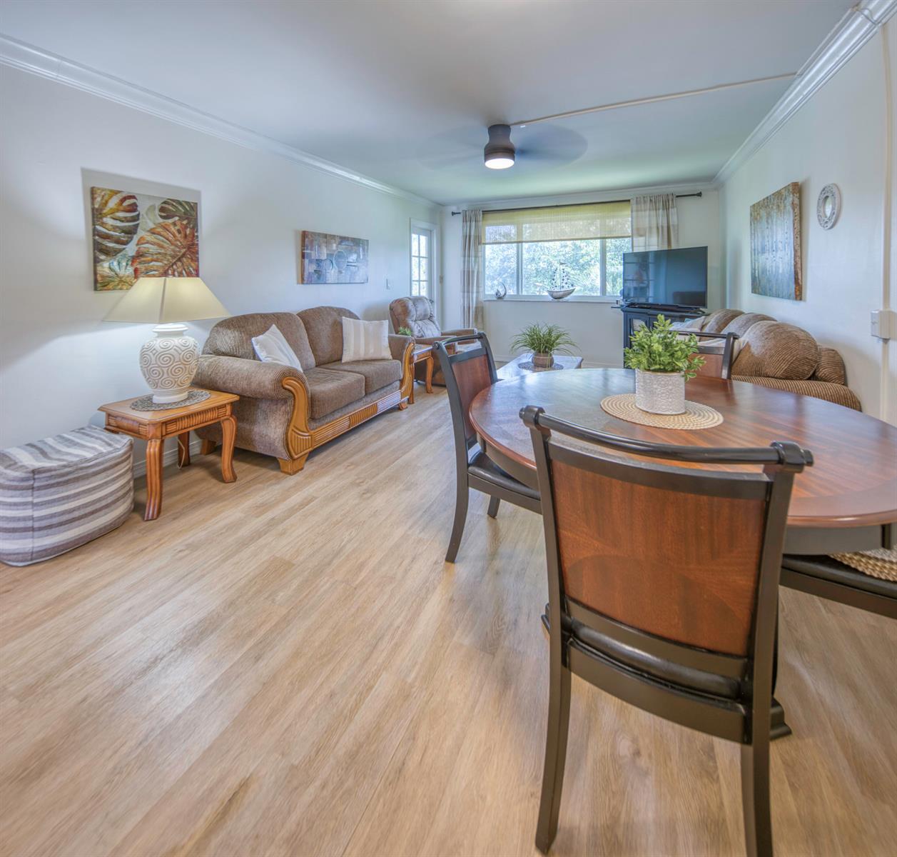 A living and dining room with wood-look flooring, a ceiling fan, and brown upholstered furniture — 2566 Garden Drive S, FL 33461, FL
