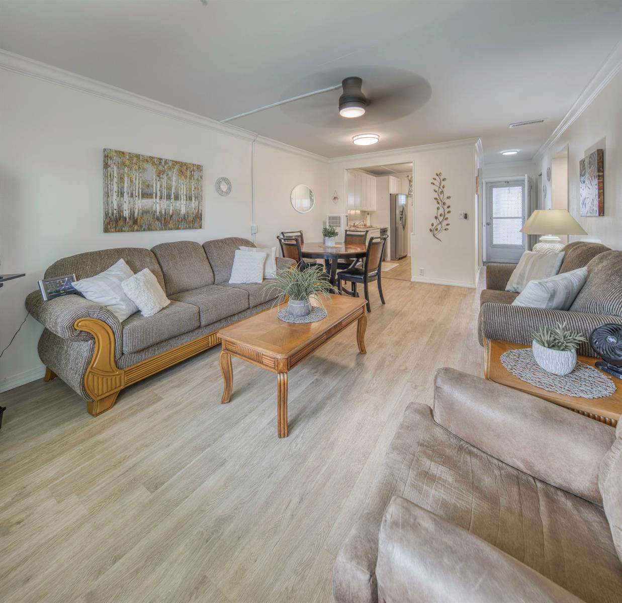 A living room with wood-look flooring, a ceiling fan, and an adjacent dining area — 2566 Garden Drive S, FL 33461, FL