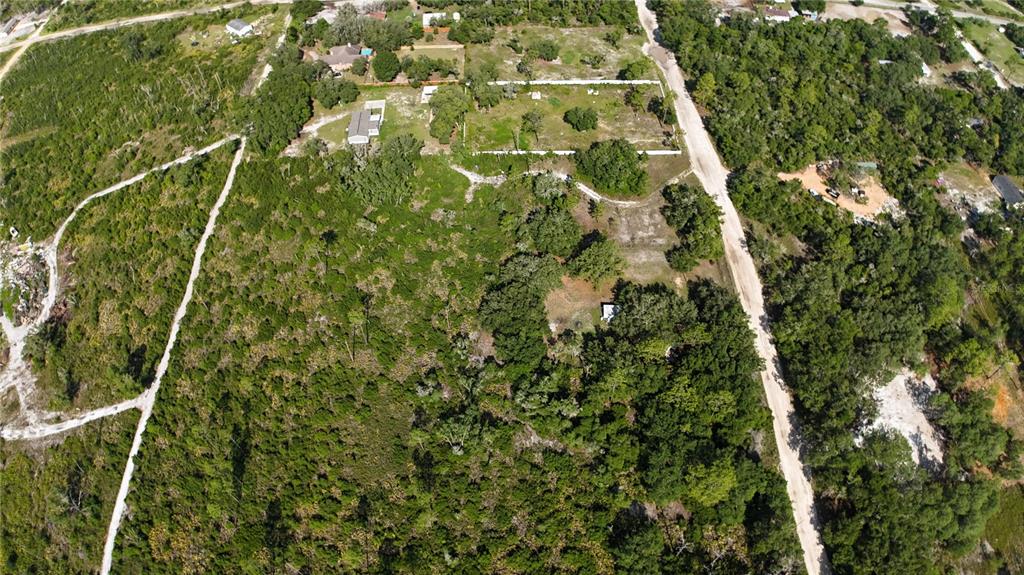 An aerial view shows a wooded lot with a dirt road and scattered houses — XX SW 156TH PLACE, DUNNELLON, FL