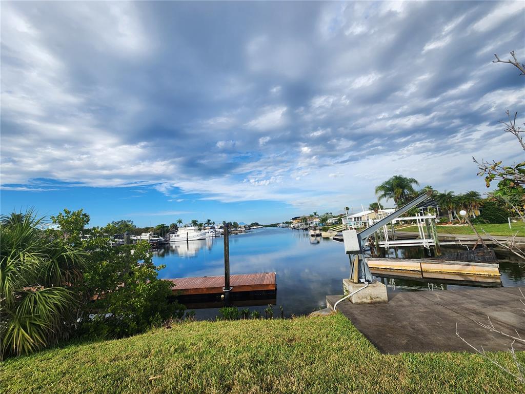 A view of a canal with boat docks, a boat lift, and several moored boats — 3532 FLORAMAR TERRACE, NEW PORT RICHEY, FL