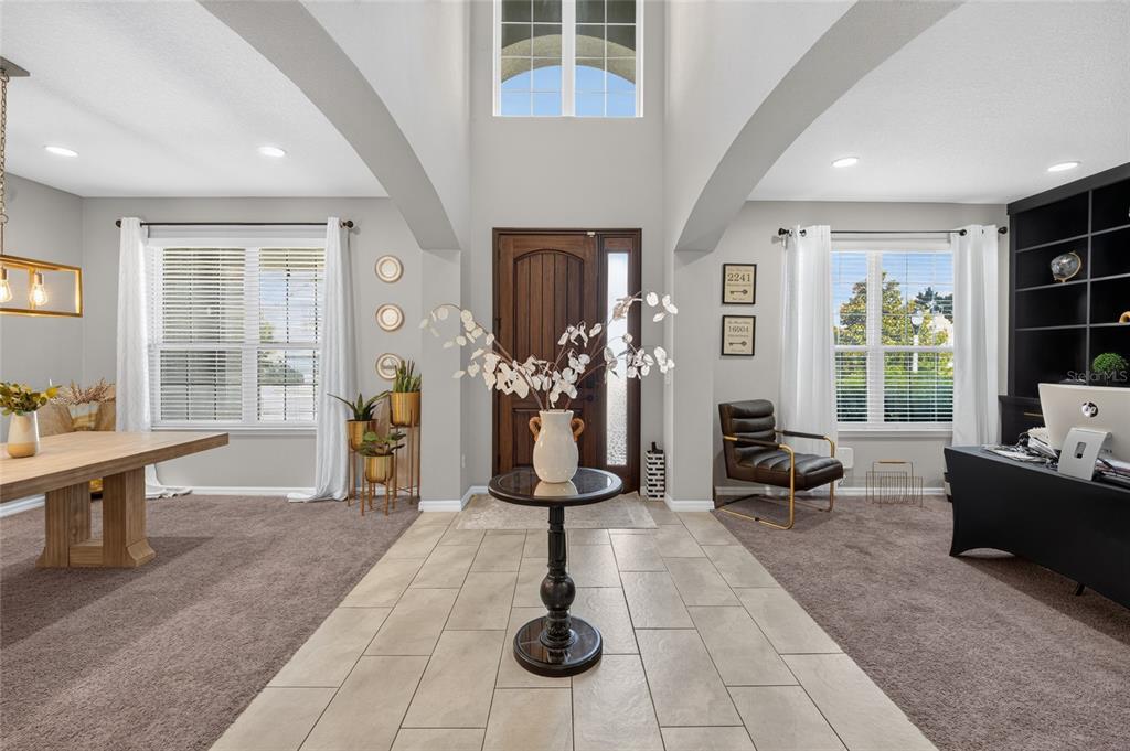 A tiled entryway leads to a high-ceilinged foyer with carpeted dining and office areas — 16004 OLLIVETT STREET, WINTER GARDEN, FL