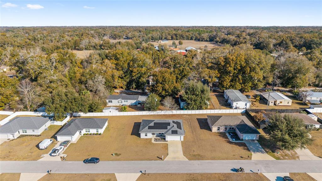 An aerial view shows three suburban houses with large yards and a white fence — 1803 NE 161ST PLACE, CITRA, FL