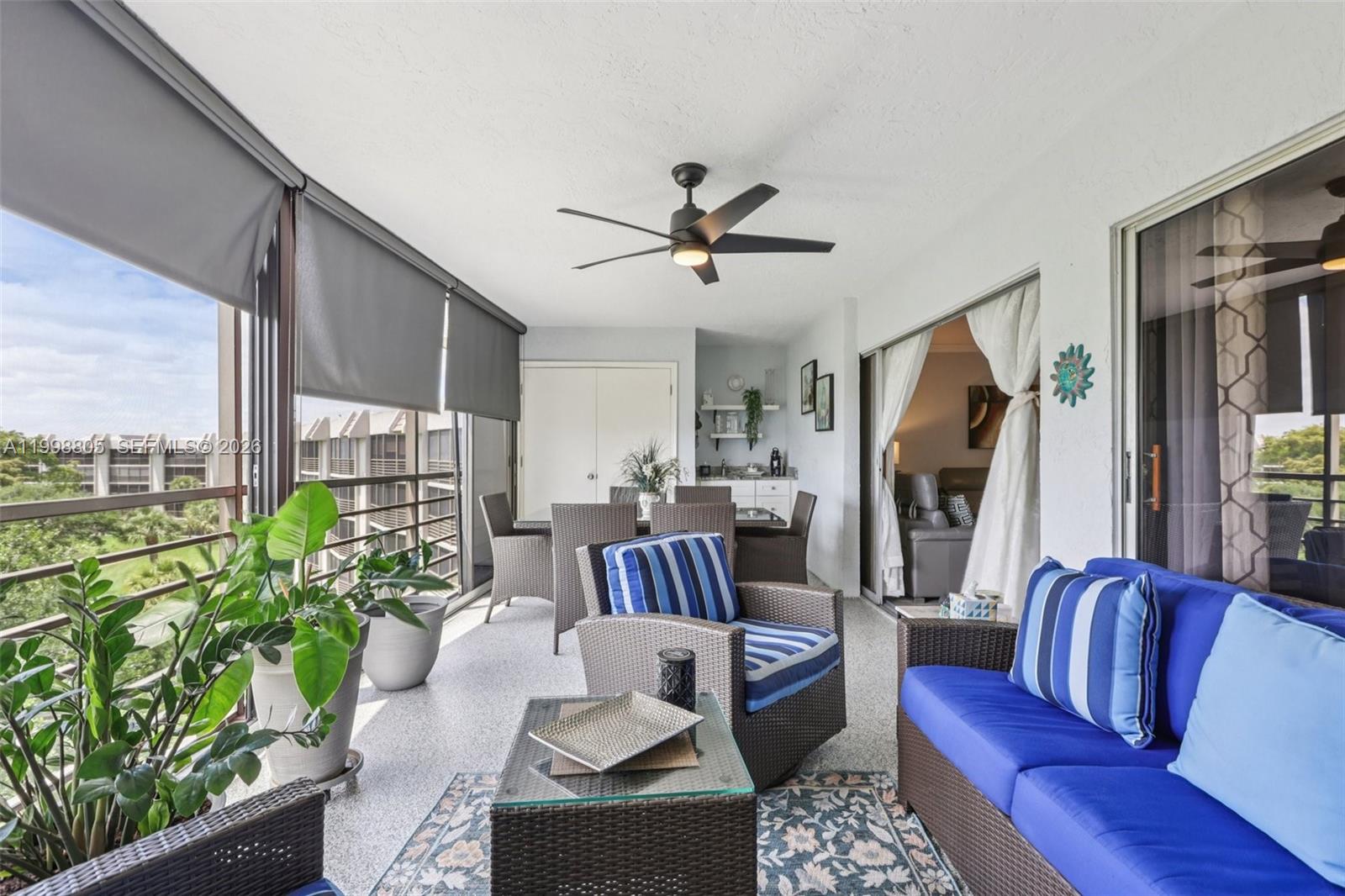 A covered balcony features wicker furniture, a ceiling fan, and views of surrounding buildings — 9170 SW 14th St # 4508, Boca Raton FL 33428, BOCA RATON, FL