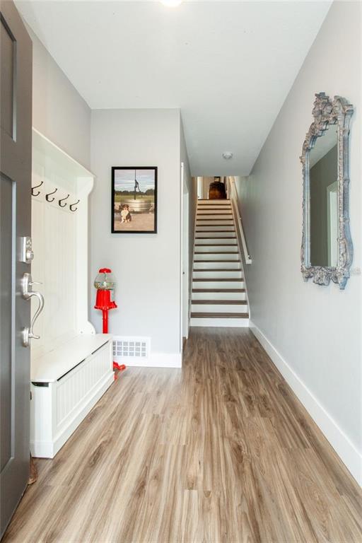 An entryway features a white bench with coat hooks, a gumball machine, and stairs — 1273 SAVONA DRIVE NE, ST PETERSBURG, FL