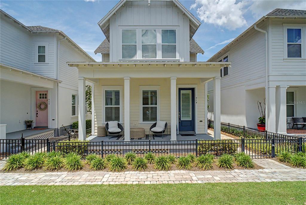 A two-story yellow house with a front porch and black metal fencing — 914 TROWMAN ALLEY, WINTER GARDEN, FL