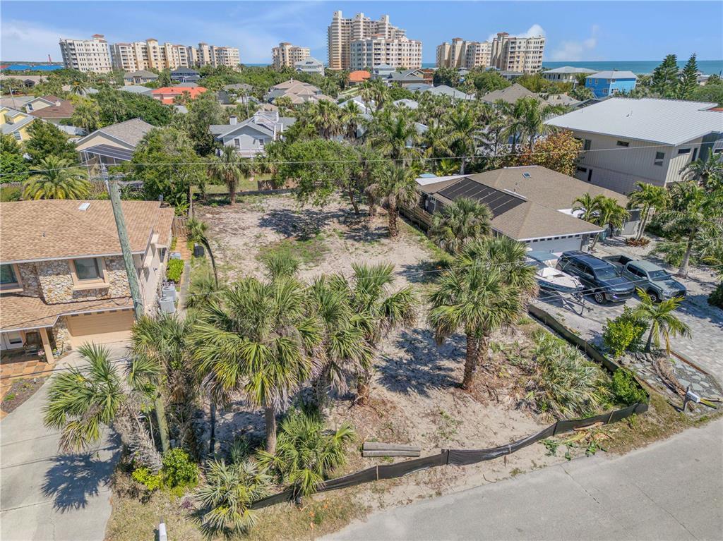 An elevated view of a vacant, sandy residential lot surrounded by houses and palm trees — 204 DUNE CIRCLE, NEW SMYRNA BEACH, FL