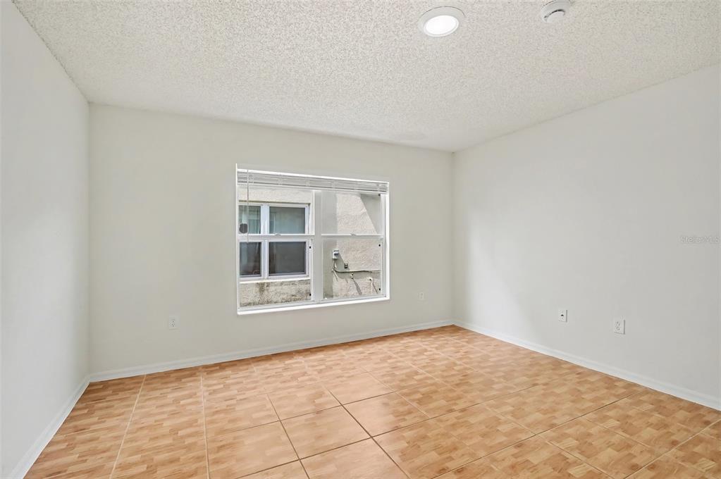 An empty room with light-colored walls, tiled flooring, a single window, and a recessed light — 1093 AMANDA KAY CIRCLE, SANFORD, FL