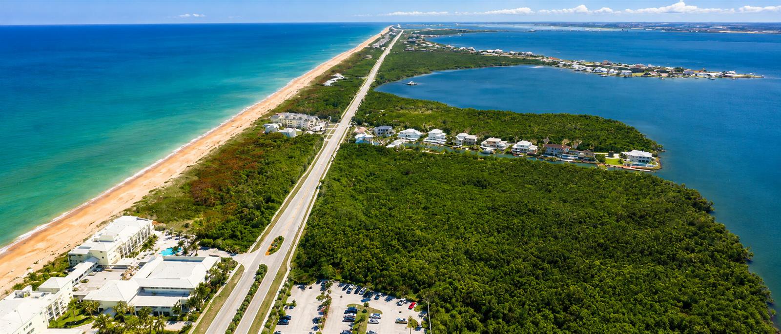 An aerial view shows a coastal road separating the ocean from a bay and forest — 3541 NE Ocean Boulevard NE # 15, Jensen Beach FL 34957, JENSEN BEACH, FL