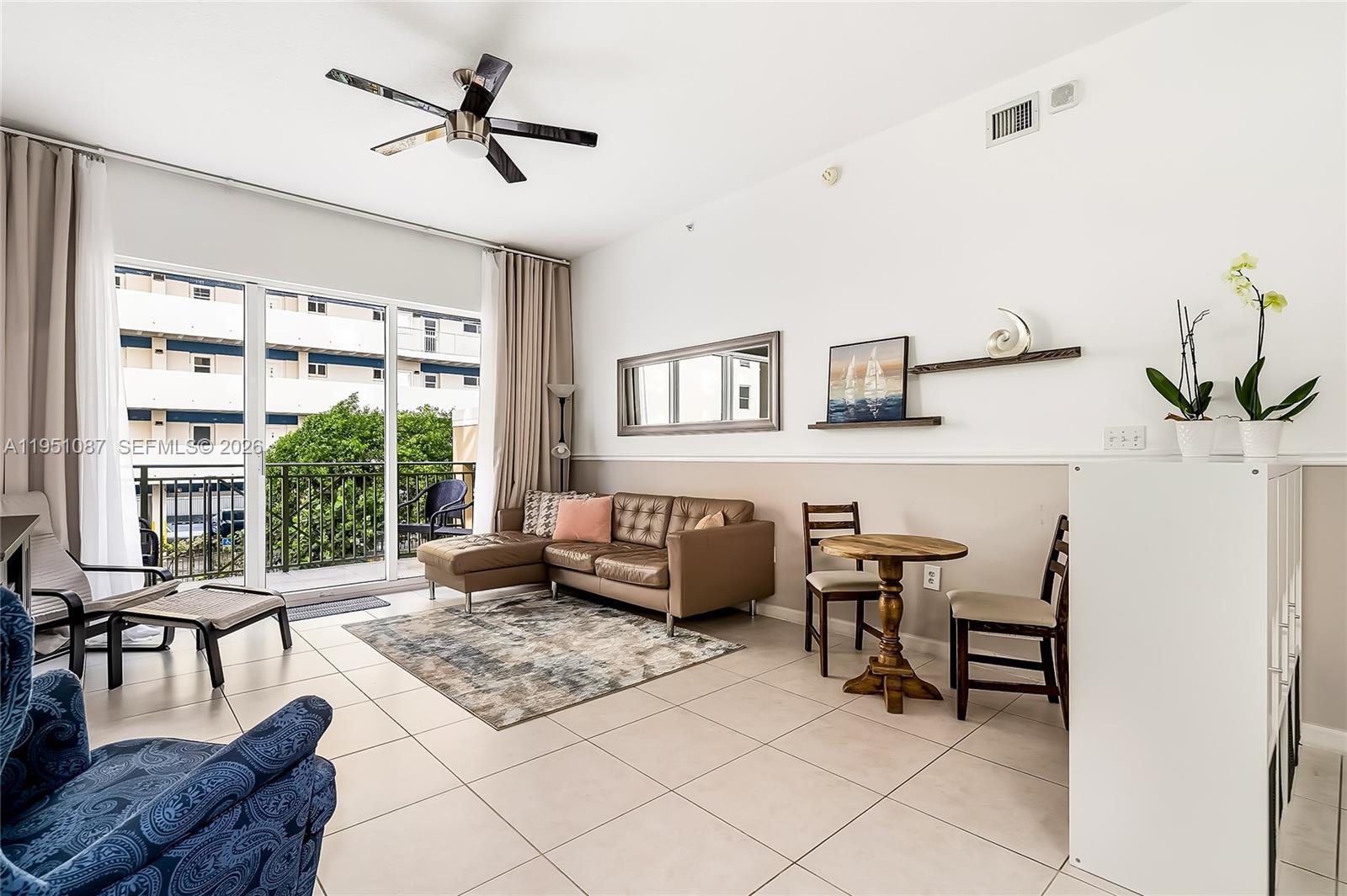 A living room features a brown sectional, a small dining set, and a balcony view — 2080 S Ocean Dr # 103, Hallandale Beach FL 33009, HALLANDALE BEACH, FL