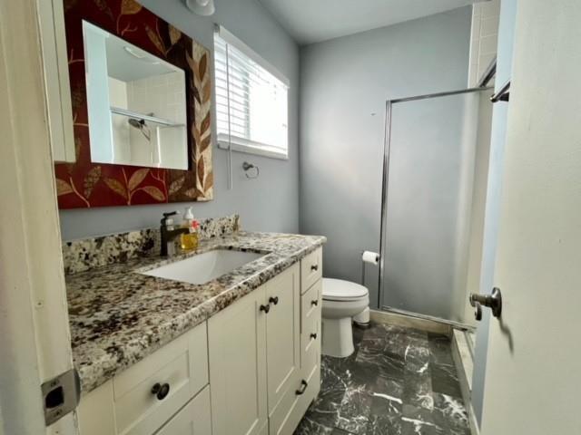 A bathroom features a granite vanity, a framed mirror, a toilet, and a glass shower — 3040 NW 1st Avenue, Pompano Beach FL 33064, POMPANO BEACH, FL