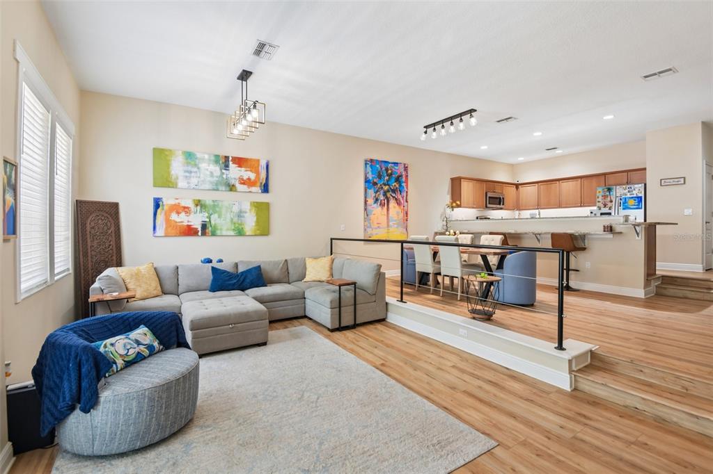 A sunken living room with a sectional sofa leads to a dining area and kitchen — 131 ATHENIAN WAY, TARPON SPRINGS, FL