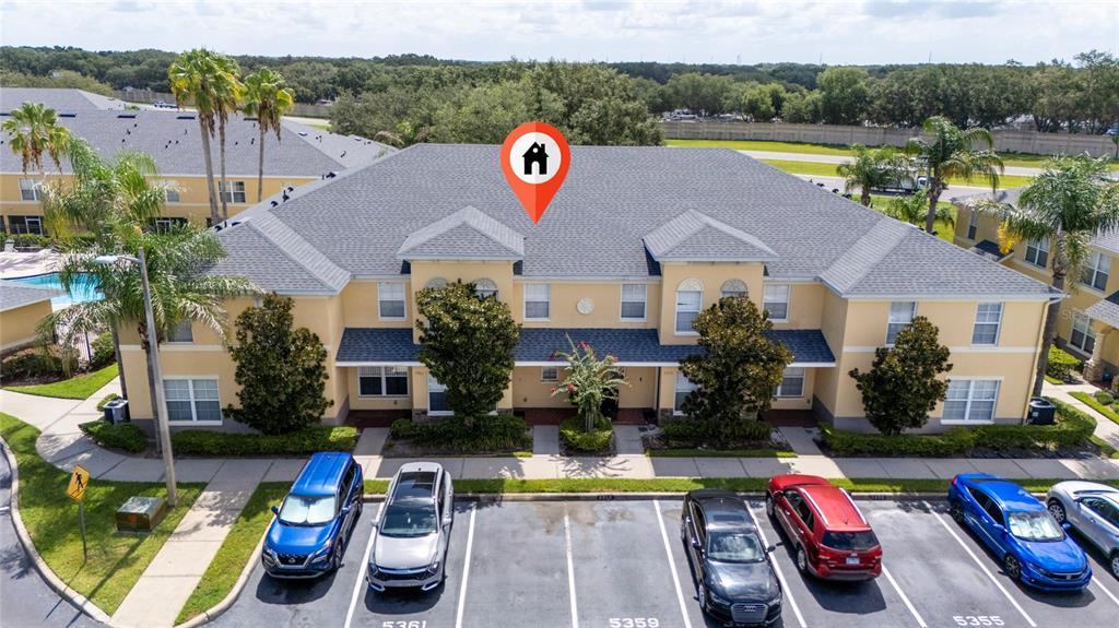 An aerial view shows a two-story apartment building with a gray roof and parking spaces — 5359 RIVER ROCK ROAD, LAKELAND, FL