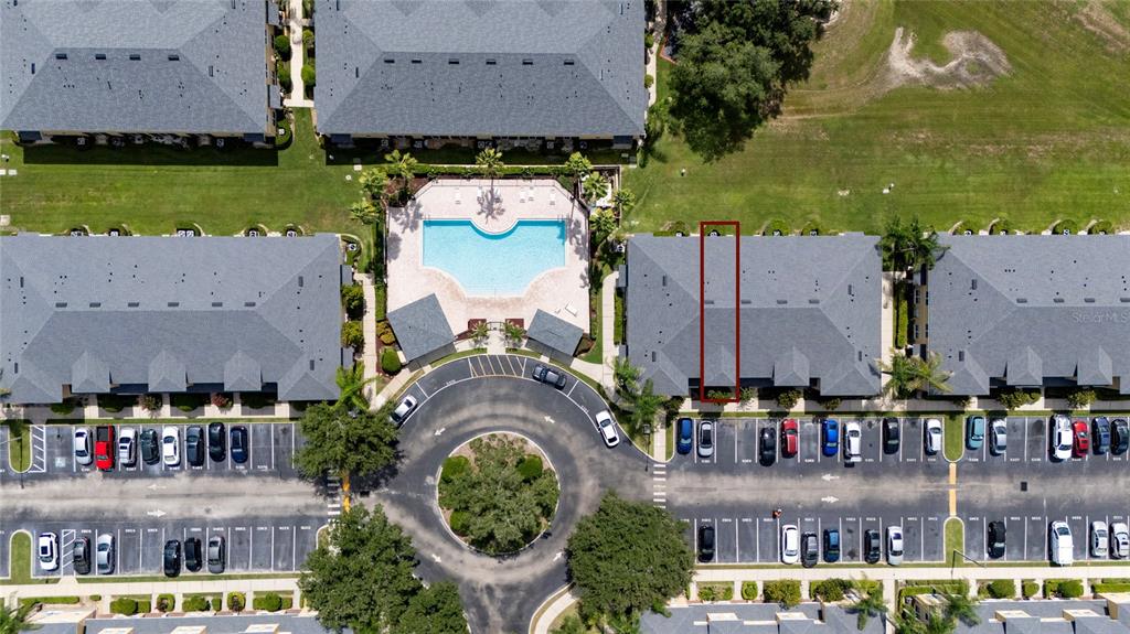 An aerial view shows apartment buildings, a swimming pool, and a parking lot — 5359 RIVER ROCK ROAD, LAKELAND, FL