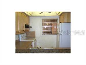 A kitchen with light wood cabinets, white appliances, and a window above the sink — 3700 S OSPREY AVENUE UNIT 212, SARASOTA, FL