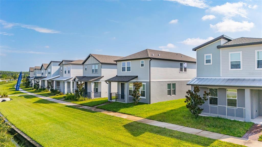 A row of modern two-story suburban houses with light-colored siding and metal roof accents — 4629 CROSS PRAIRIE PARKWAY, ST CLOUD, FL