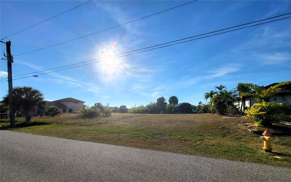 A vacant, grassy residential lot sits next to a paved road with a fire hydrant — 9620 PRESIDENT CIRCLE, PORT CHARLOTTE, FL