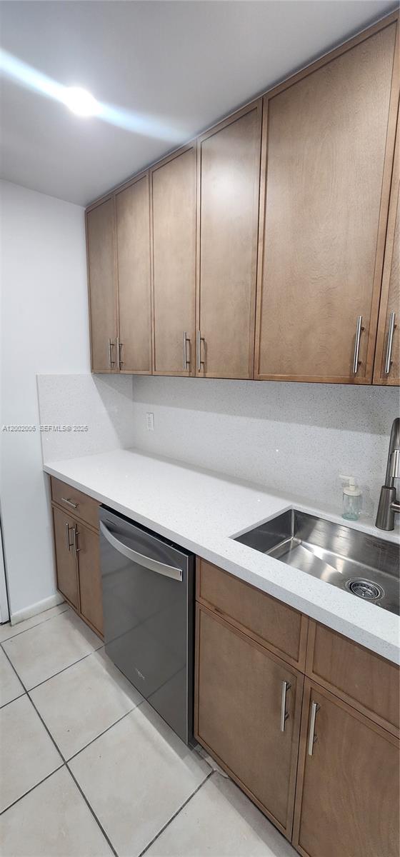 A kitchen features wood cabinets, white countertops, a stainless steel sink, and a dishwasher — 500 NE 2nd St # 213, Dania Beach FL 33004, DANIA BEACH, FL