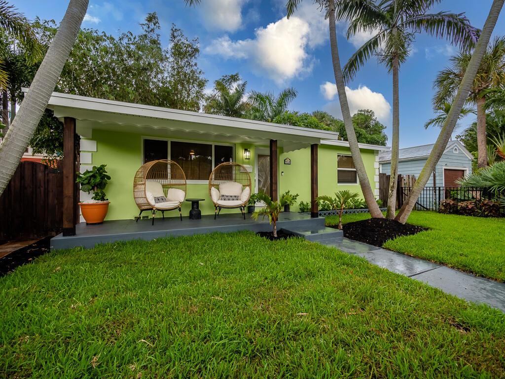 A lime green house with a covered front porch featuring two wicker egg chairs — 418 N Palmway, FL 33460, FL