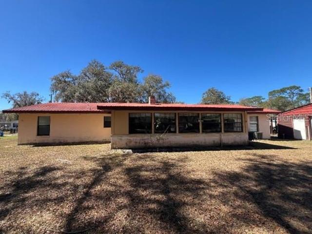 A single-story house with a red metal roof and a large enclosed porch — 5875 NE 167TH AVENUE, SILVER SPRINGS, FL