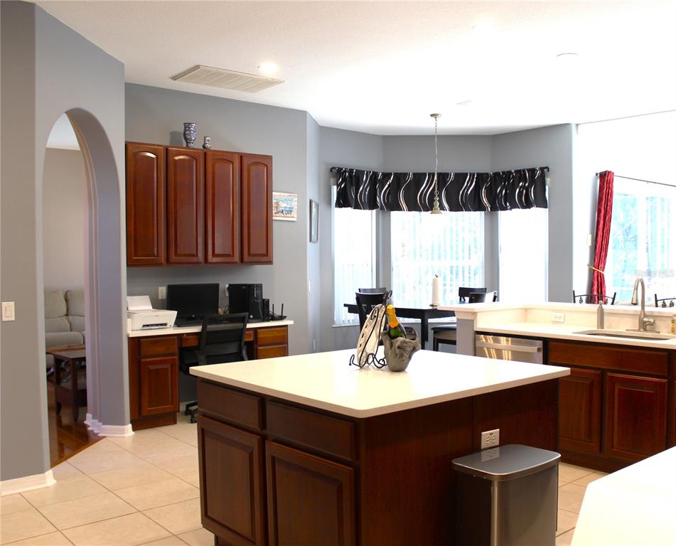 A dining area and entryway feature hardwood floors, a chandelier, and a dark wood hutch — 3817 BIRCH MOUNTAIN ROAD, PORT ORANGE, FL
