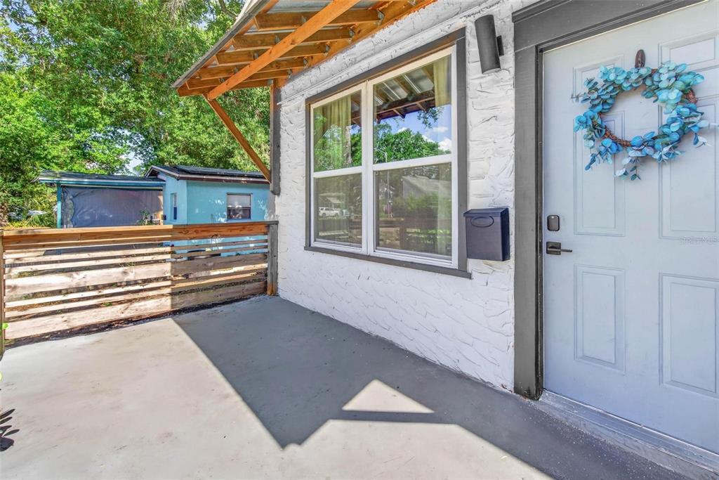 A white brick exterior wall features a window, a mailbox, and a light blue door — 4556 YARMOUTH AVENUE S, ST PETERSBURG, FL