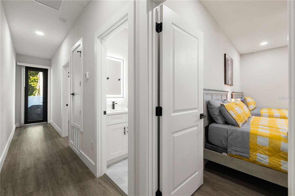 A hallway leads to a glass door, a bathroom, and a bedroom with two beds — 174-176 S LEMON AVENUE, BROOKSVILLE, FL