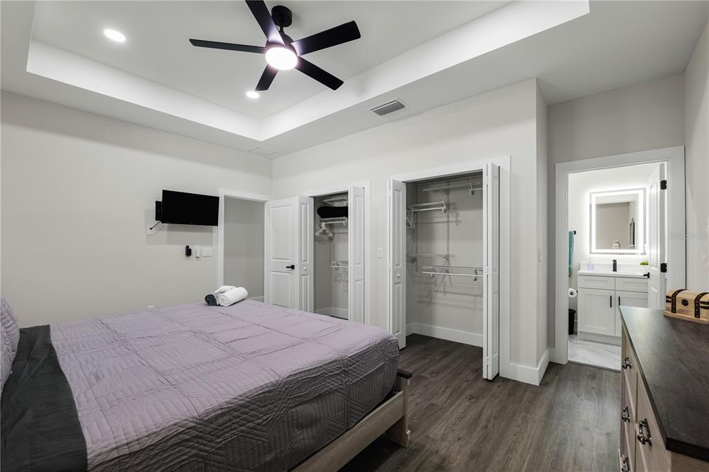 A bedroom features a tray ceiling, two closets, dark wood flooring, and an attached bathroom — 174-176 S LEMON AVENUE, BROOKSVILLE, FL