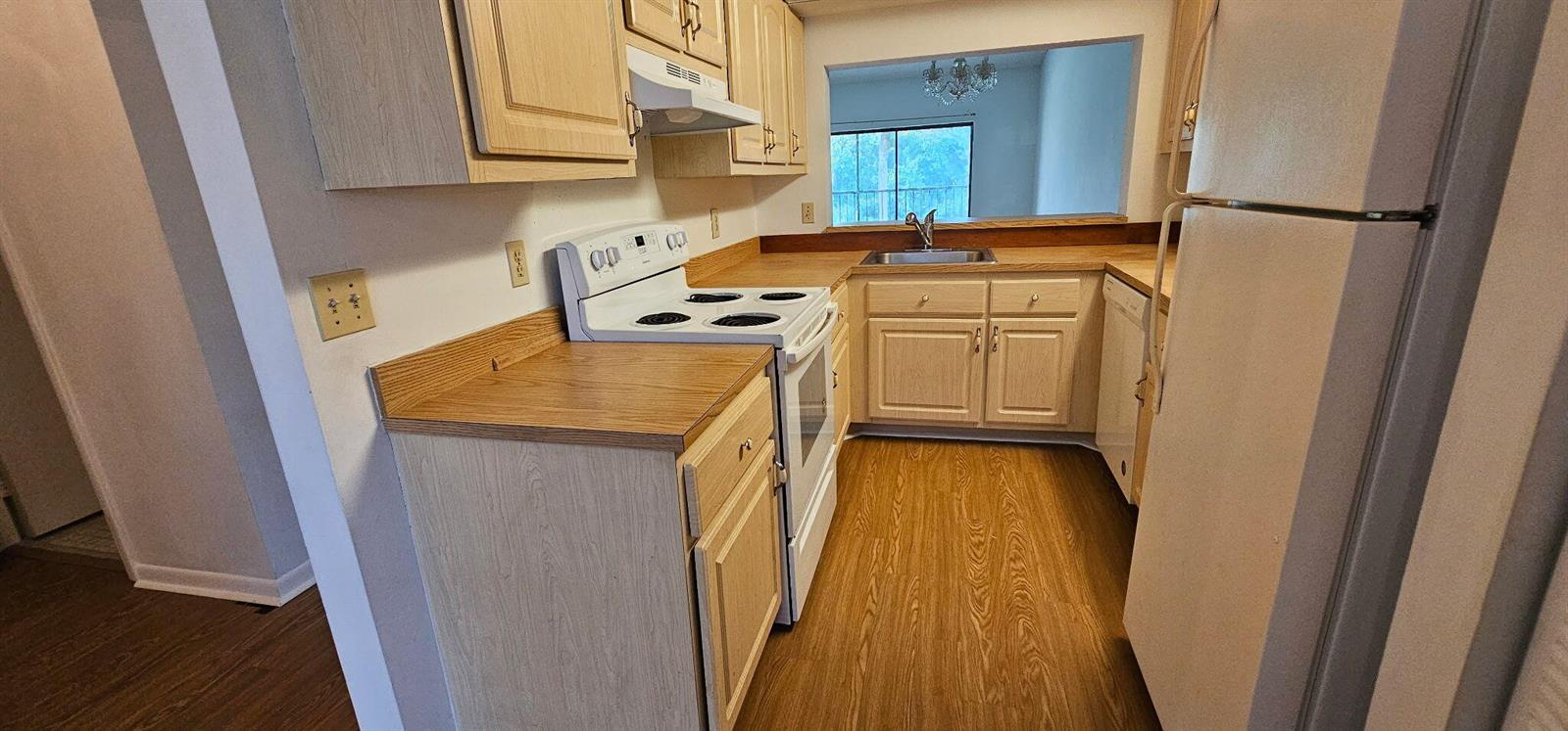 A kitchen with light wood cabinets, white appliances, and wood-look flooring — 7879 Willow Spring Drive # 923, Lake Worth FL 33467, LAKE WORTH, FL