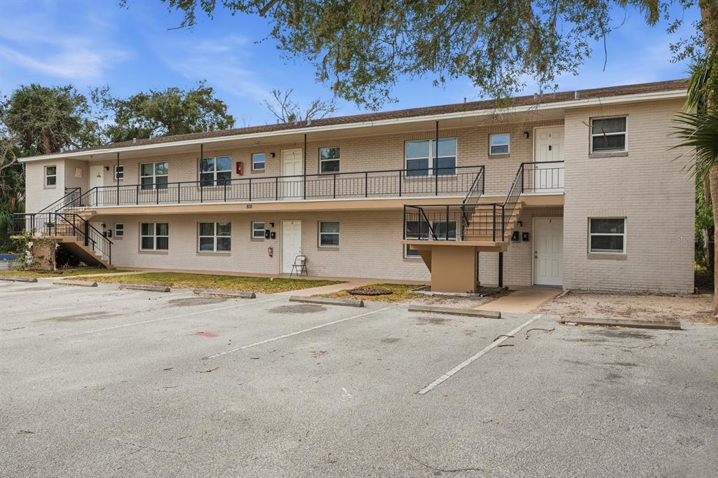 A two-story brick apartment building with exterior walkways and a parking lot in front — 805 LOUISVILLE STREET, PORT ORANGE, FL