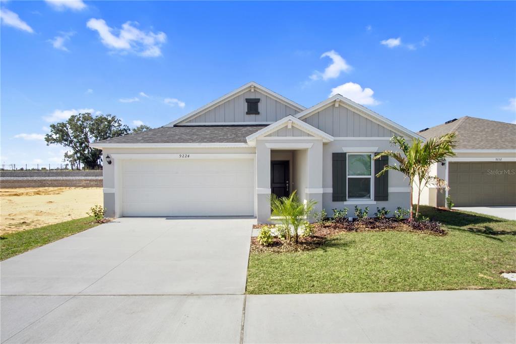 A single-story suburban house features a two-car garage, gray siding, and a small front lawn — 9224 WESTSIDE HILLS DRIVE, DAVENPORT, FL