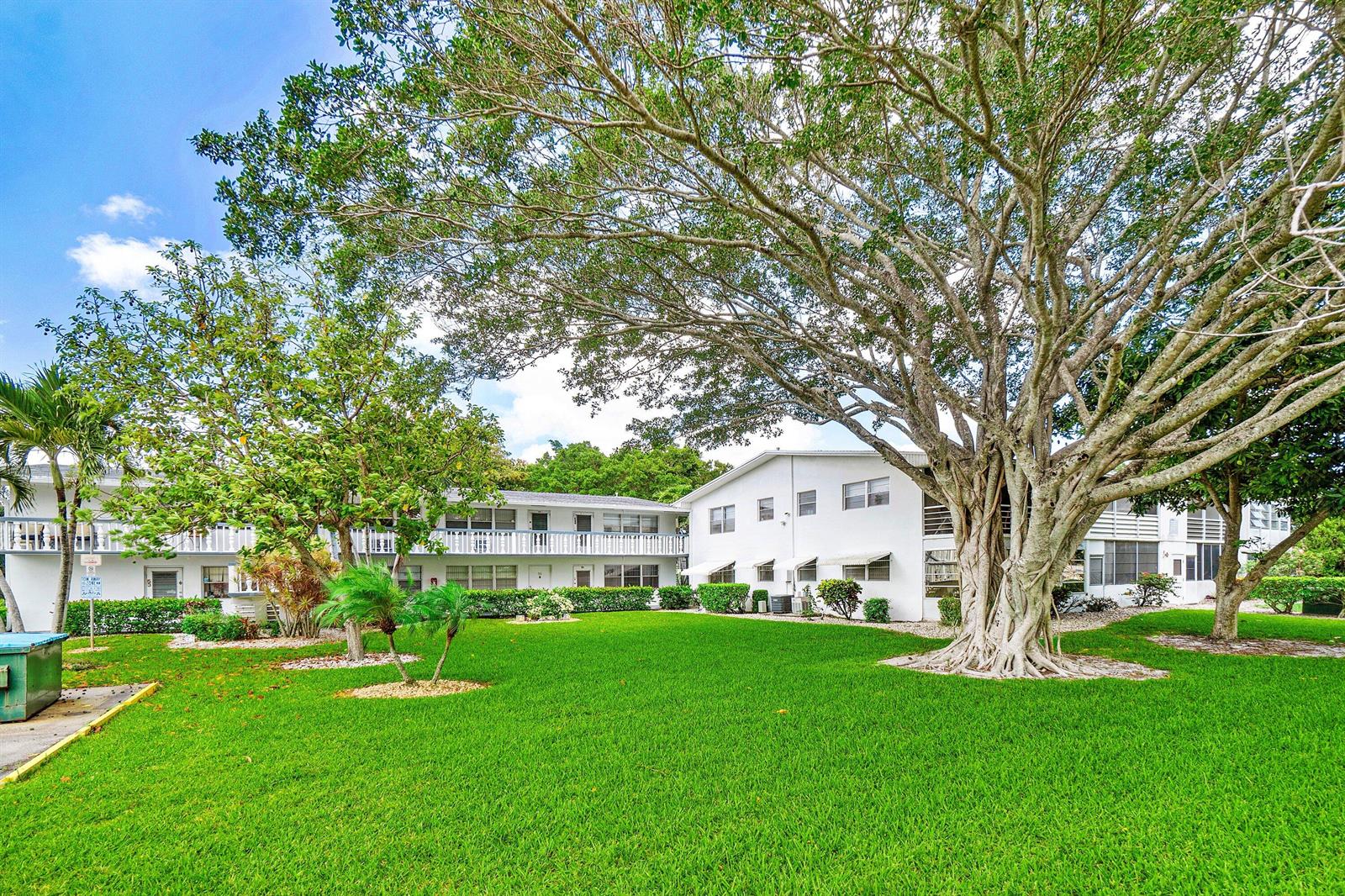 A large banyan tree stands on a grassy lawn in front of a white apartment building — 57 Canterbury, West Palm Beach FL 33417, WEST PALM BEACH, FL