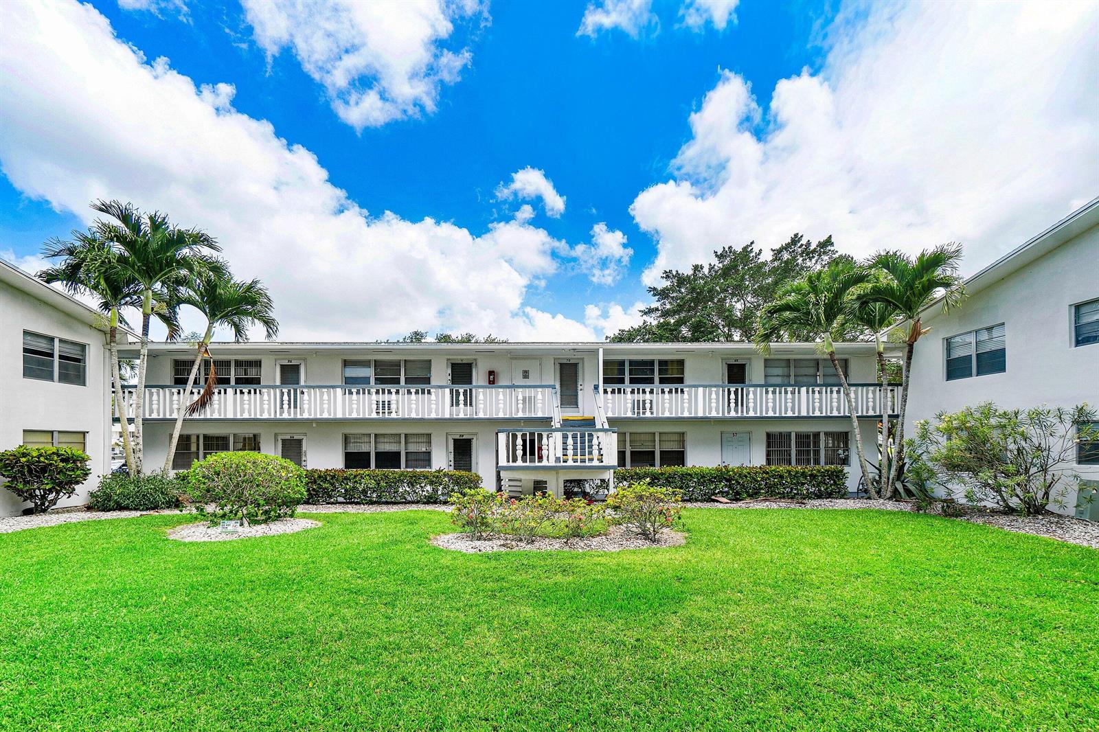 A two-story white apartment building with a central staircase and a grassy courtyard — 57 Canterbury, West Palm Beach FL 33417, WEST PALM BEACH, FL