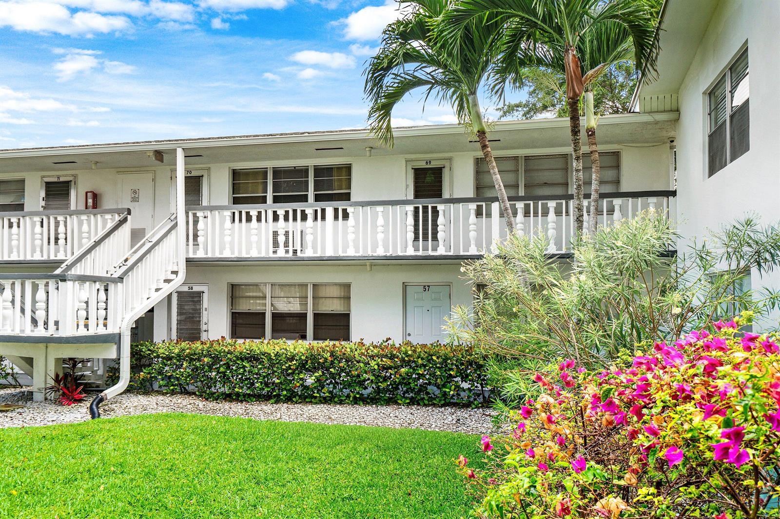 A two-story apartment building features white exterior walls, a balcony, and a landscaped front yard — 57 Canterbury, West Palm Beach FL 33417, WEST PALM BEACH, FL