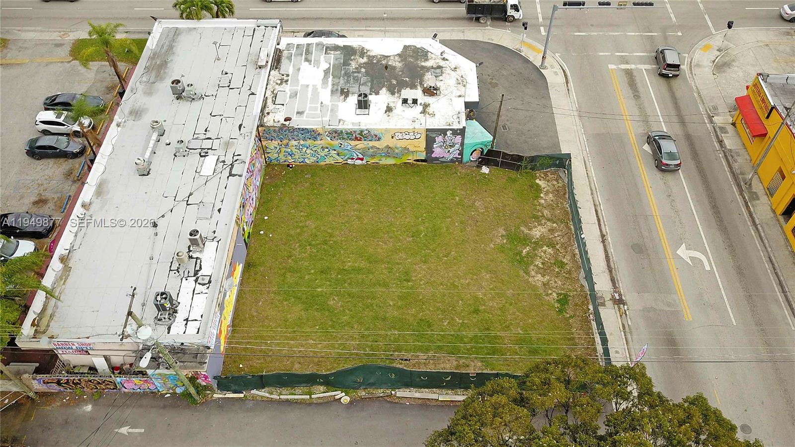 An aerial view shows a vacant grassy lot situated between two commercial buildings — 2219 NW 28th St, Miami FL 33142, MIAMI, FL