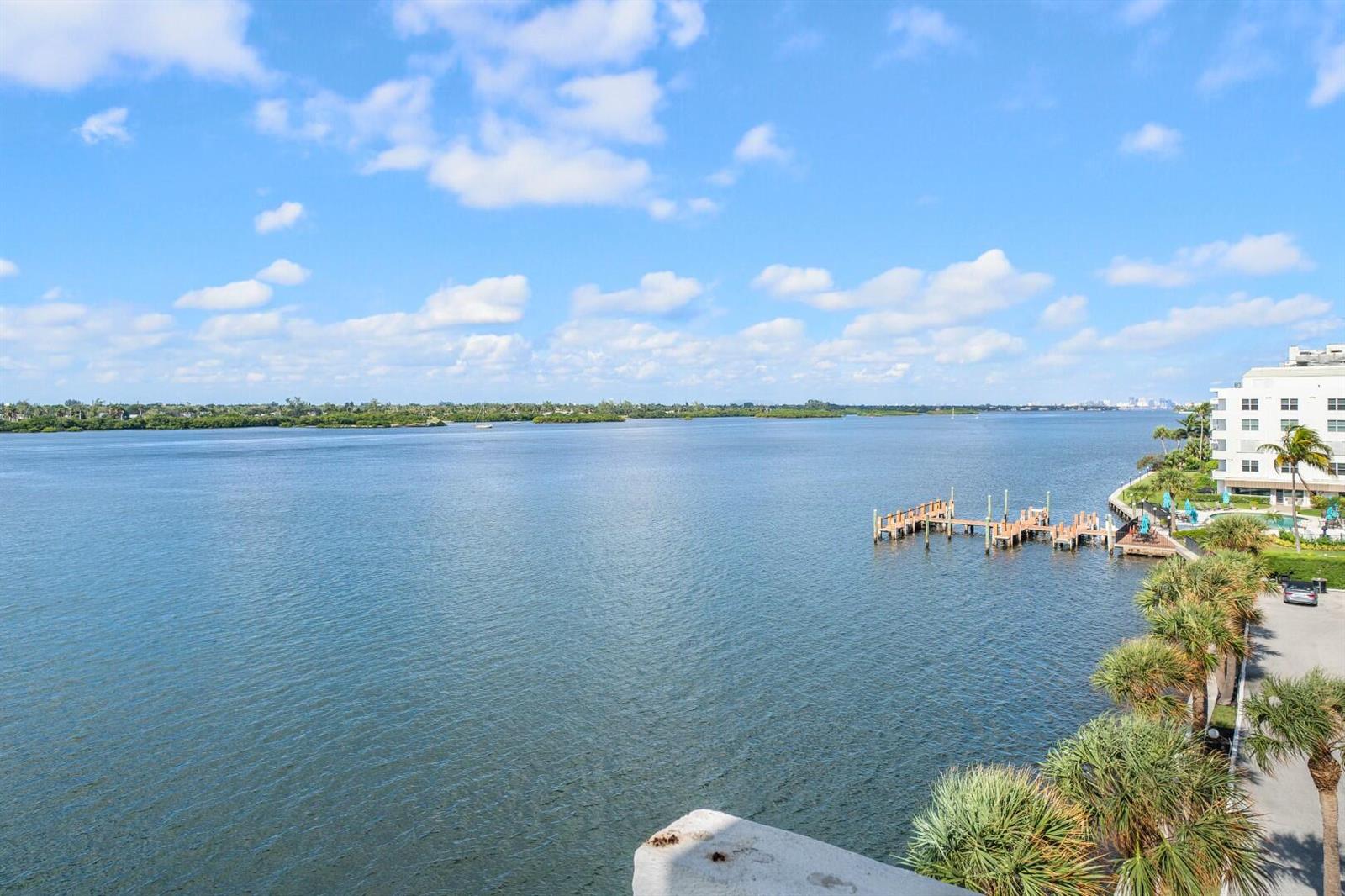An elevated view of a calm bay with a wooden dock and palm trees — 2860 S Ocean Boulevard # 506, Palm Beach FL 33480, PALM BEACH, FL