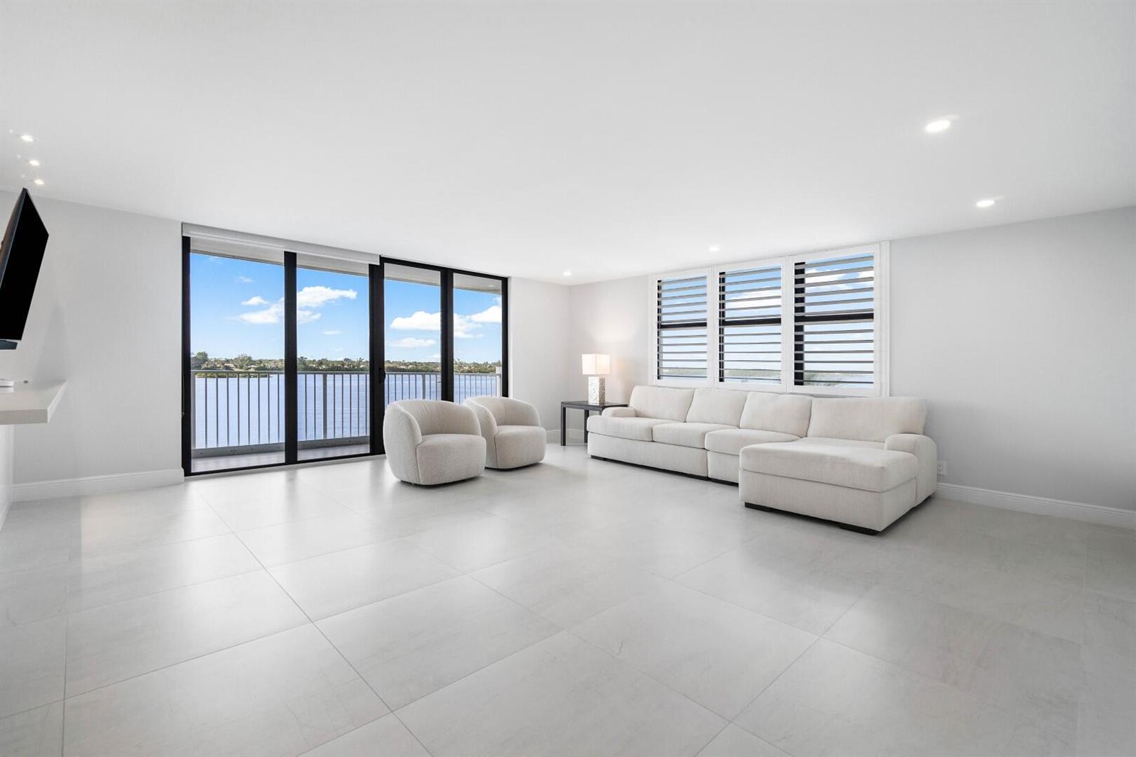 A bright living room features white tile floors, a sectional sofa, and floor-to-ceiling windows — 2860 S Ocean Boulevard # 506, Palm Beach FL 33480, PALM BEACH, FL
