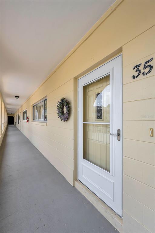 An exterior view of a building hallway with a white door labeled 35 — 2223 PHILIPPINE DRIVE UNIT 35, CLEARWATER, FL