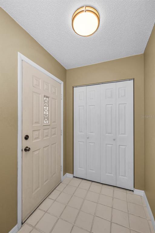 An entryway features a white front door, a white bi-fold closet, and tiled flooring — 2223 PHILIPPINE DRIVE UNIT 35, CLEARWATER, FL
