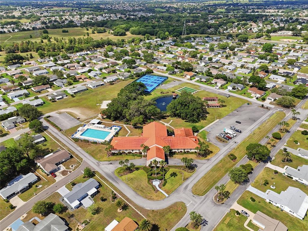 An aerial view shows a community clubhouse with a pool, tennis courts, and surrounding homes — 17814 SE 107TH TERRACE, SUMMERFIELD, FL